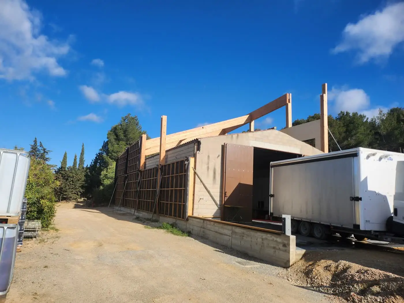 La cave en chantier : quai de réception de vendange et charpente bois en cours de montage