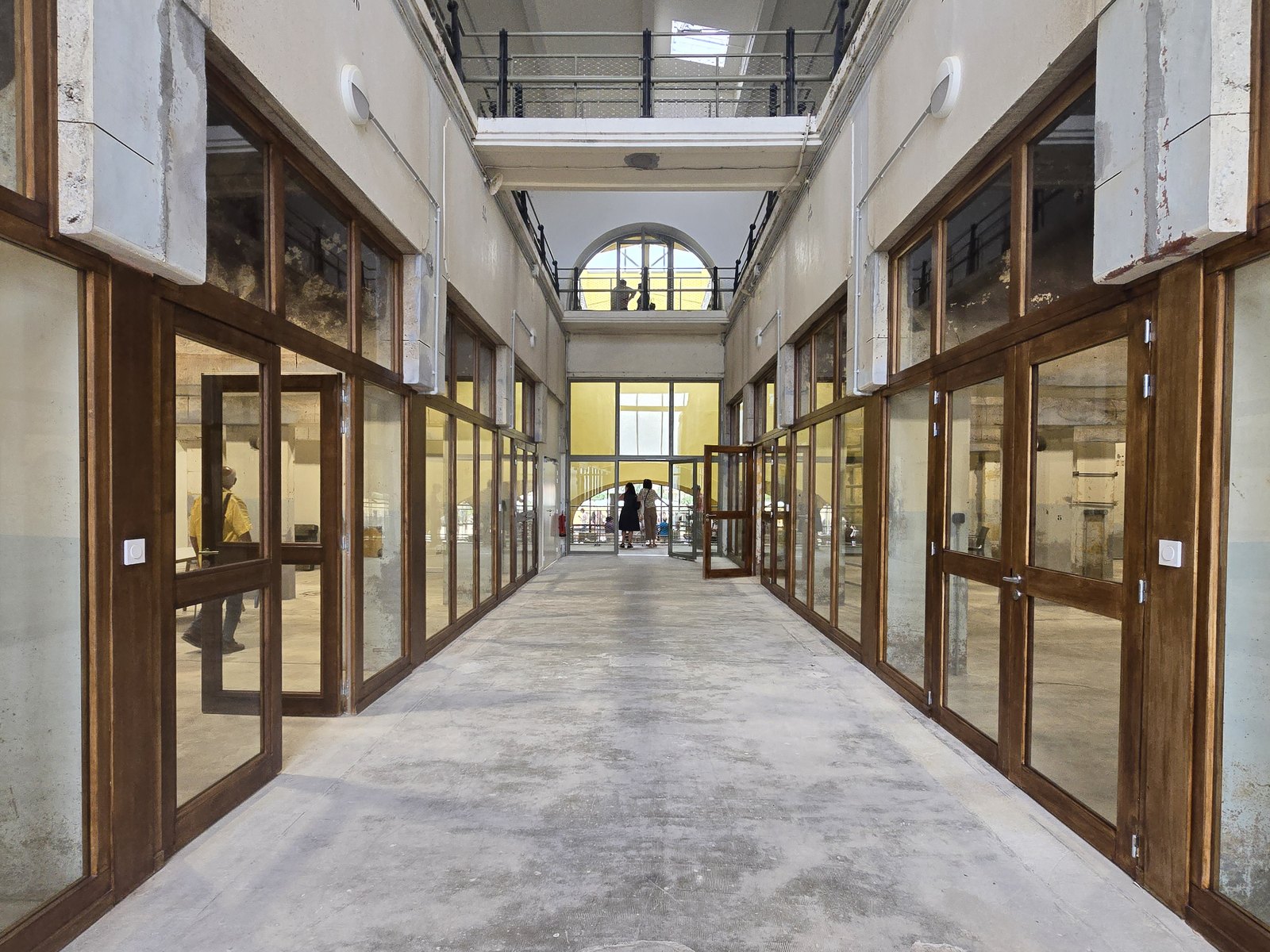 La même allée après transformation : ateliers vitrés à menuiseries bois de part et d'autre