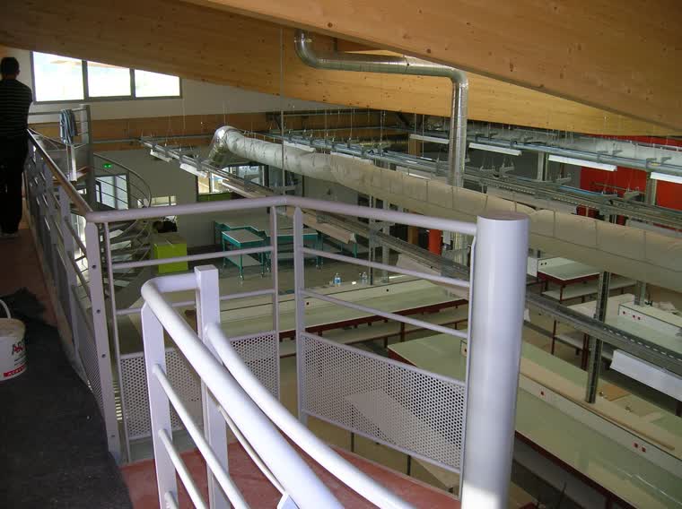 Laboratoire d'œnologie aménagé sur deux niveaux avec mezzanine et réseaux apparents