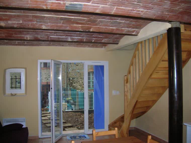 Grande baie vitrée neuve installée à côté d'un escalier en bois