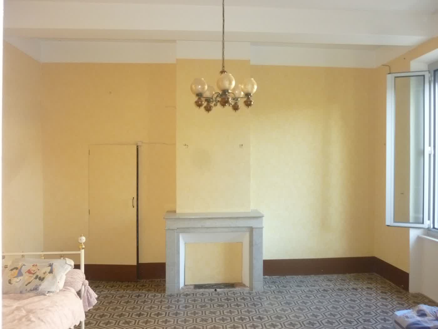 La même chambre avant travaux, murs jaunes et cheminée ancienne
