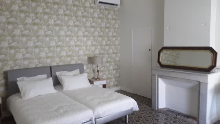 Chambre contemporaine aux murs clairs et à la literie blanche après rénovation