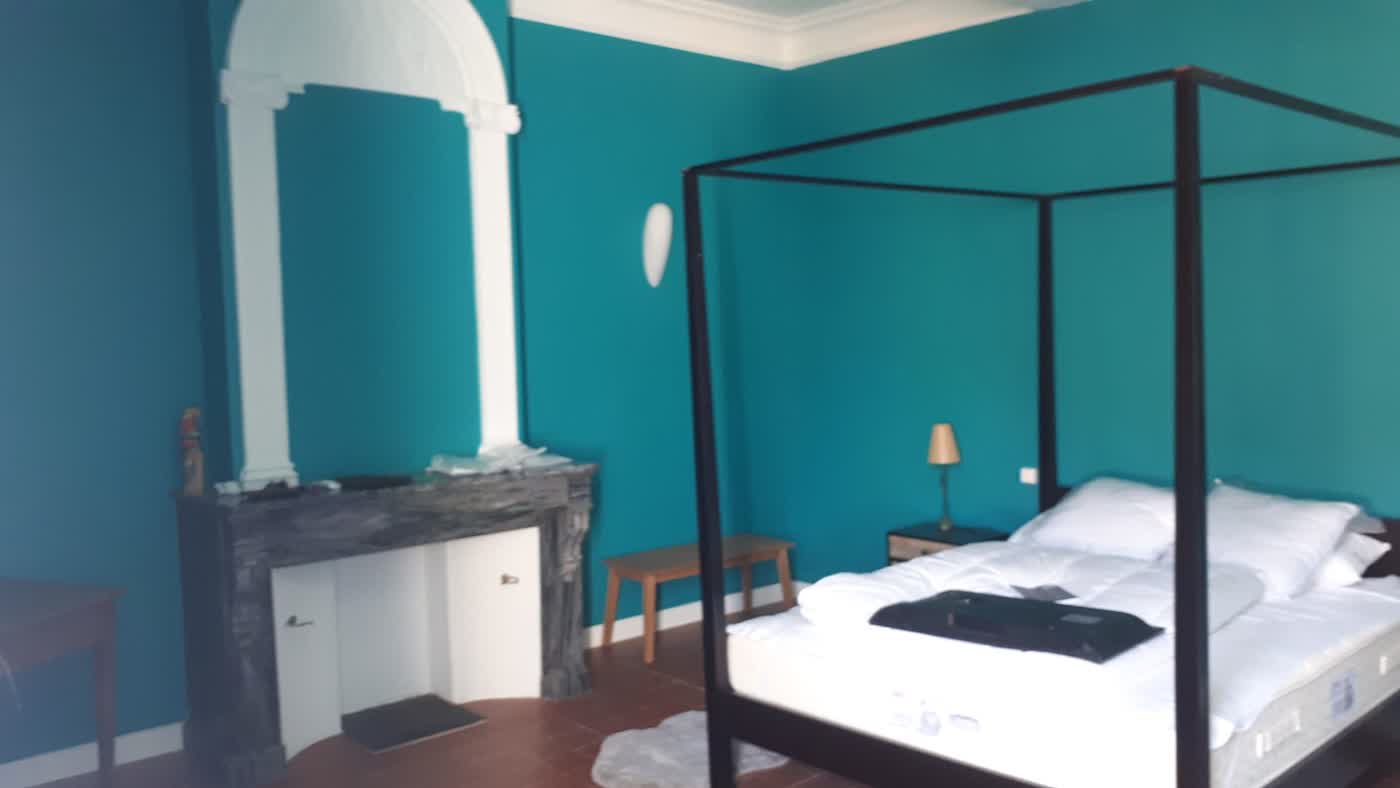 Chambre de gîte après rénovation, teinte bleue et lit à baldaquin