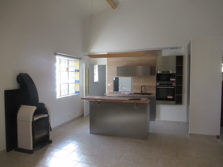 Cuisine ouverte contemporaine avec îlot central, plan bois et poêle à bois, après rénovation