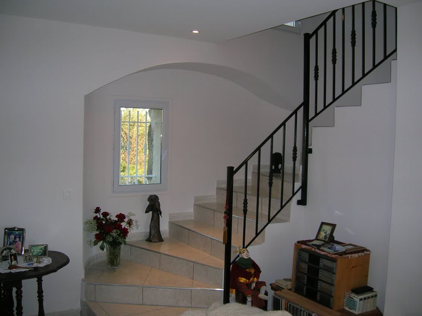 Entrée de maison rénovée : arche maçonnée, escalier en pierre, garde-corps en fer forgé