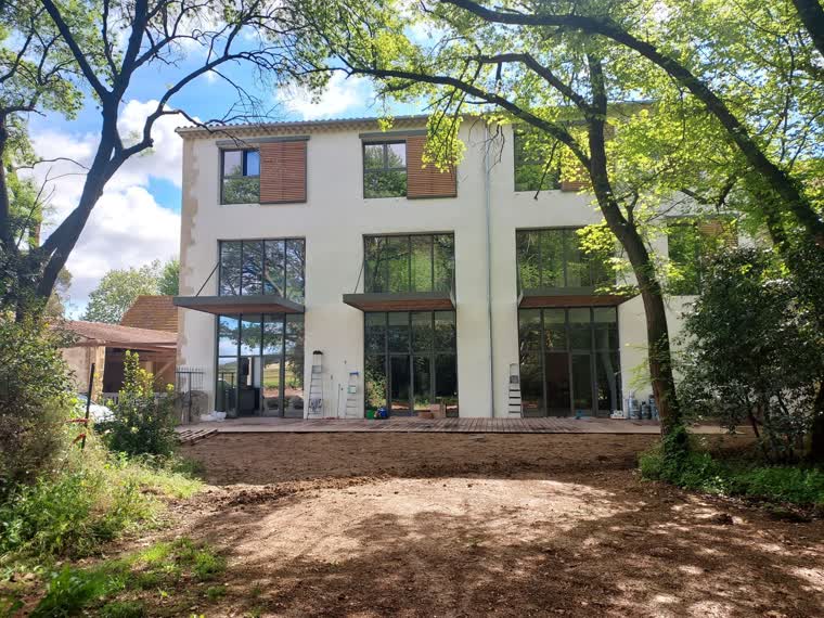 Bâtisse réhabilitée en gîtes : façade contemporaine, grandes baies vitrées et brise-soleil bois