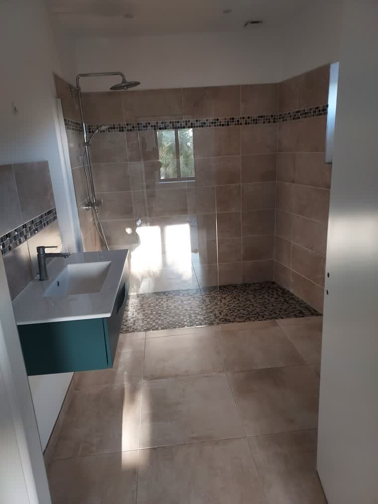 Salle de bains rénovée avec douche à l'italienne, frise mosaïque et meuble vasque suspendu
